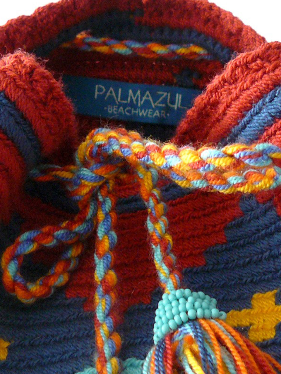 Close up Diamond pattern orange, yellow, red and blue woven shoulder bag with tassels and beads Palmazul Beachwear Wayuu Mochila